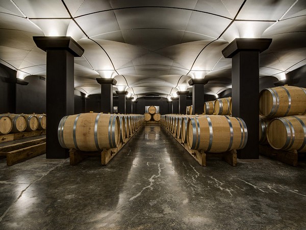 Cave avec barriques bordelaises, pilier noir et marbre noir au sol