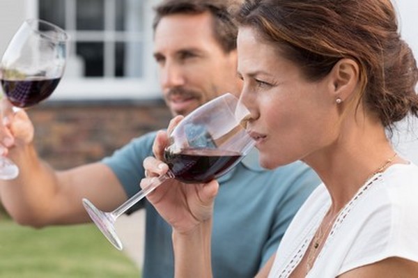 Couple déguste vin rouge en extérieu