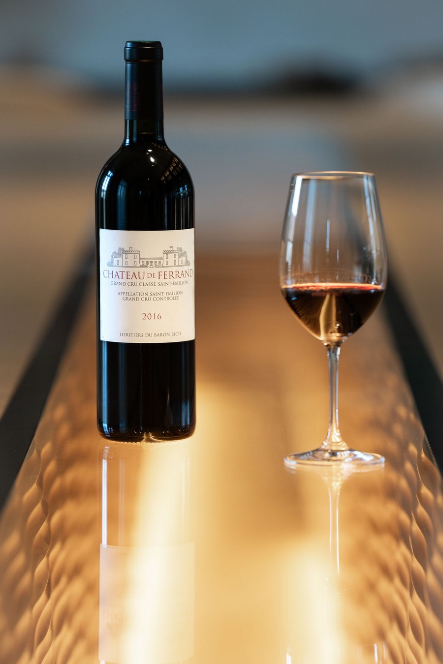 Bouteille de vin Château de Ferrand Grand Cru Classé et verre de vin rouge 