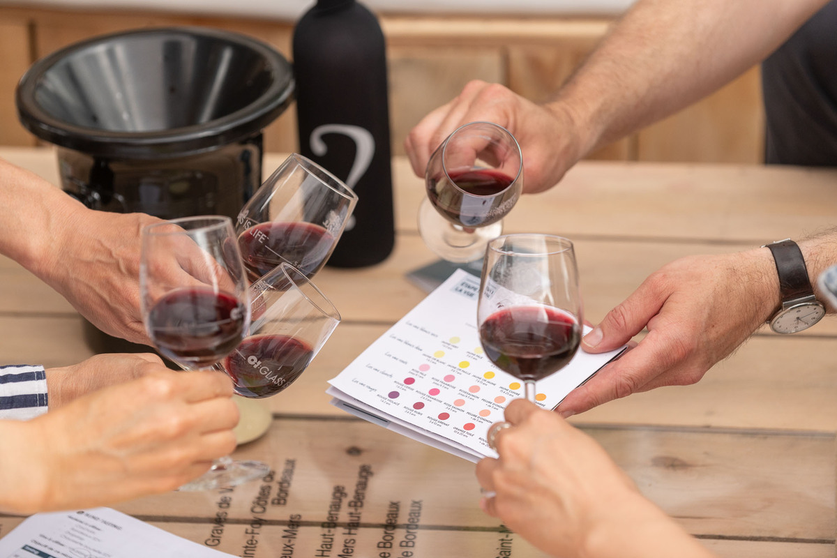 Cinq verres de vin rouge inclinés, crachoir et fiche couleur vin