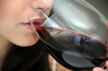 Gros plan dame qui déguste verre vin rouge